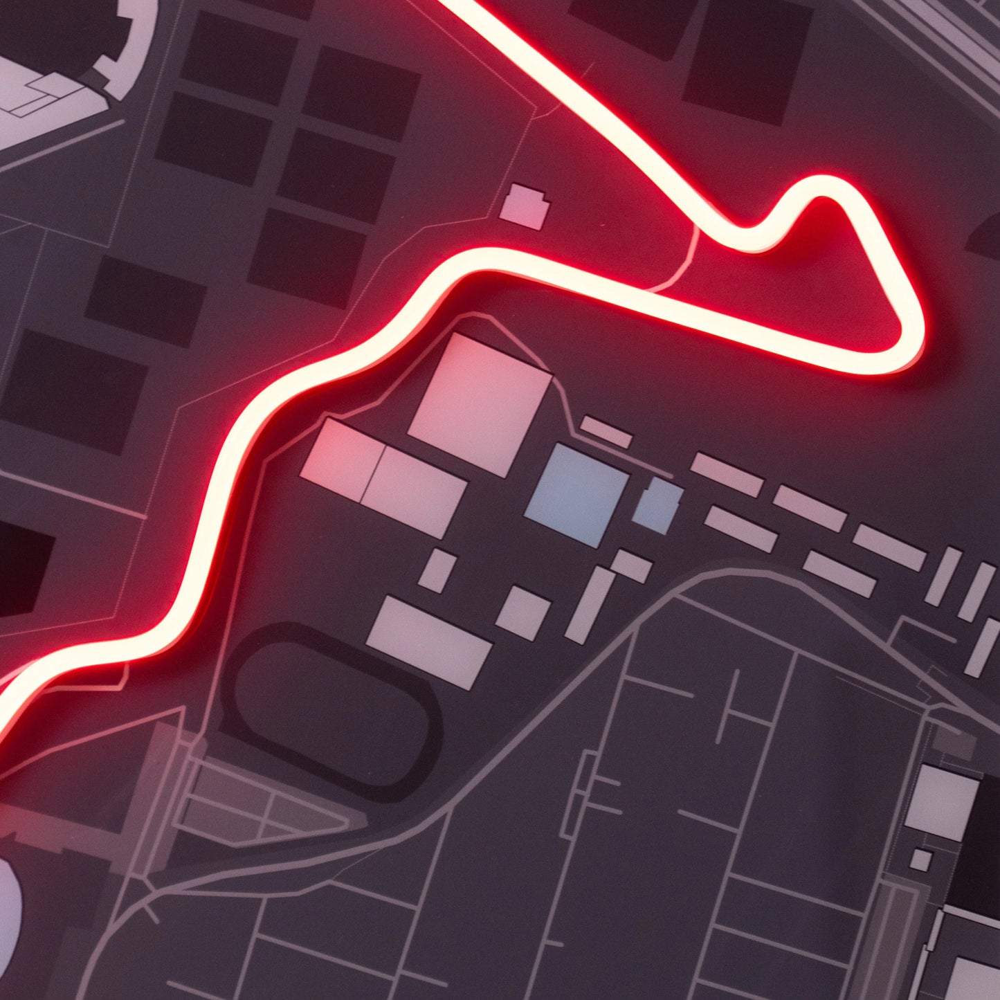 Dark city map with glowing red neon route line highlighting streets and buildings layout