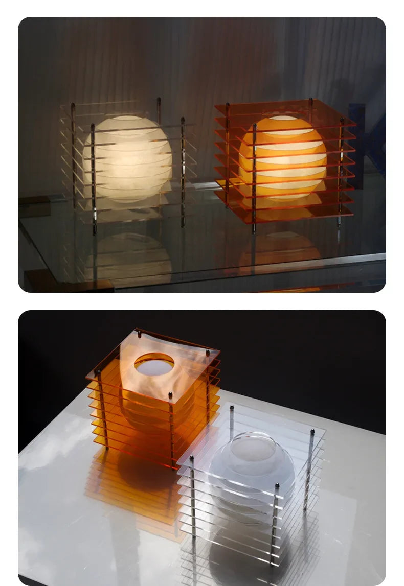 Modern spherical table lamps with layered acrylic cube frames in clear and orange on glass and white surfaces