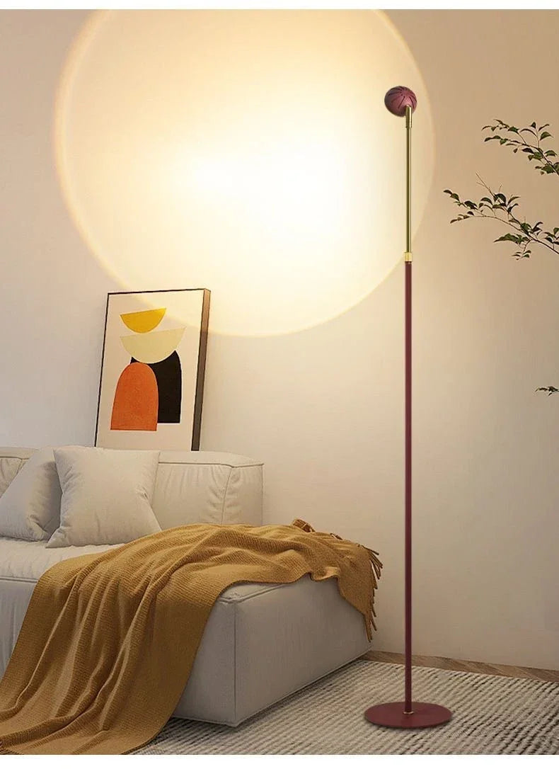 Modern floor lamp casting circular light over white sofa with mustard throw and abstract wall art