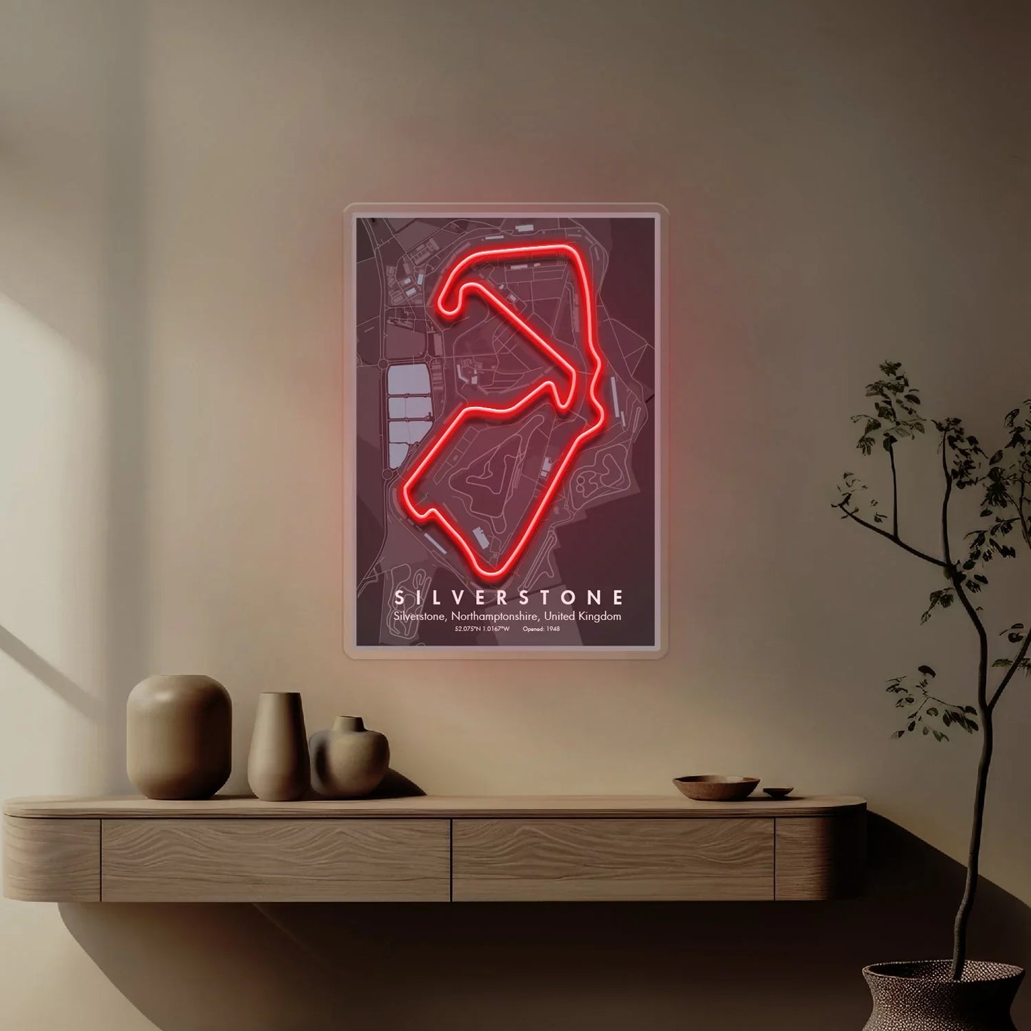 Interior wall with illuminated Silverstone Formula 1 circuit map in red neon above wooden shelf with vases
