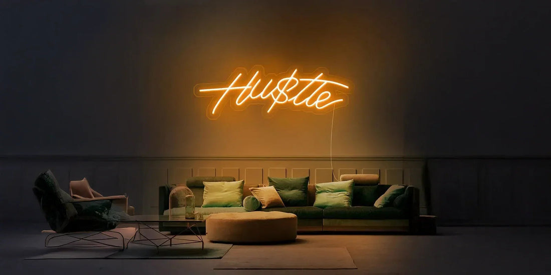 Modern living room with green velvet sofa, round ottoman, lounge chair, and orange neon Hustle sign