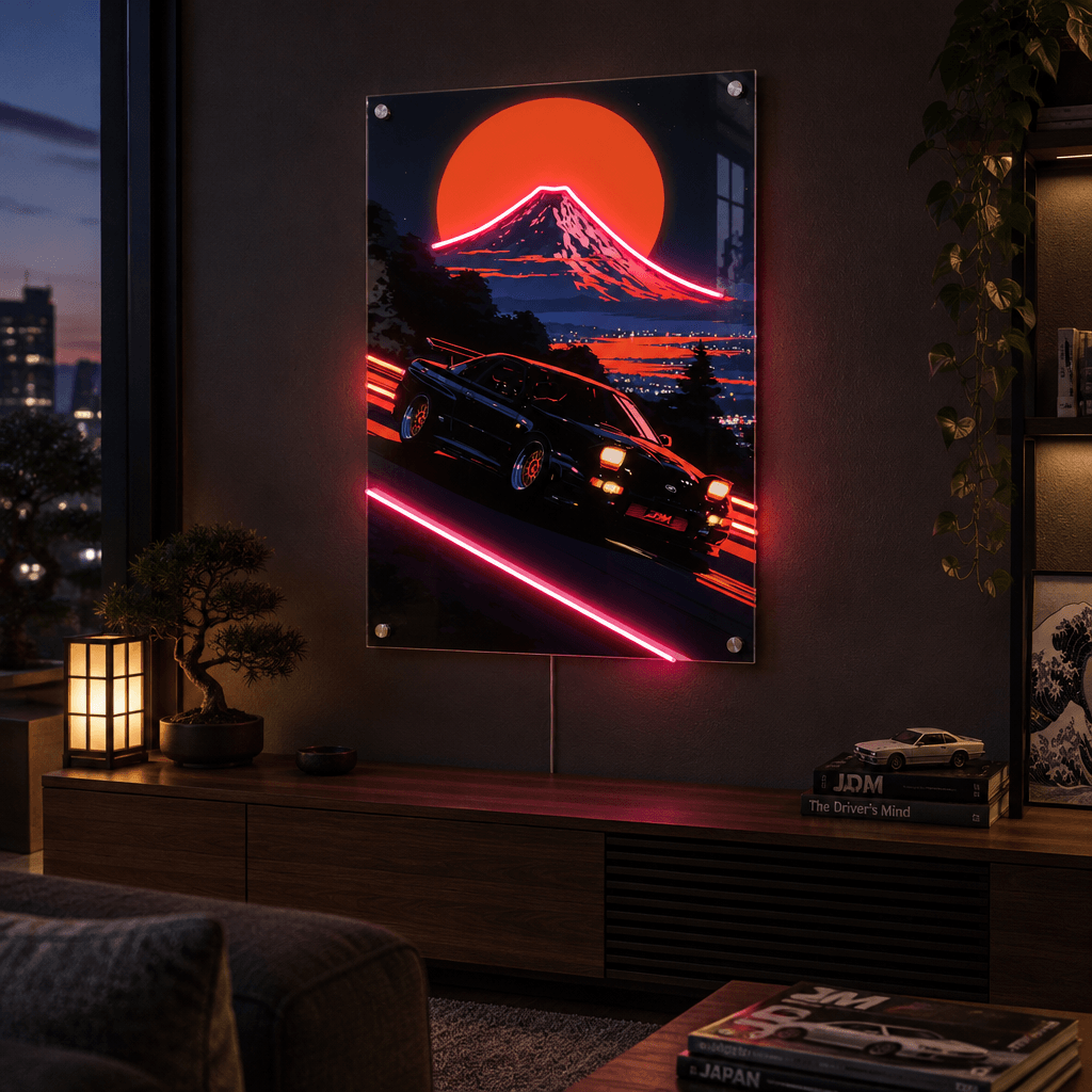 Glowing LED neon acrylic wall art of a retro sports car speeding past Mount Fuji at sunset, mounted in a dark moody modern living room.