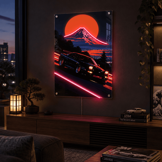 Glowing LED neon acrylic wall art of a retro sports car speeding past Mount Fuji at sunset, mounted in a dark moody modern living room.