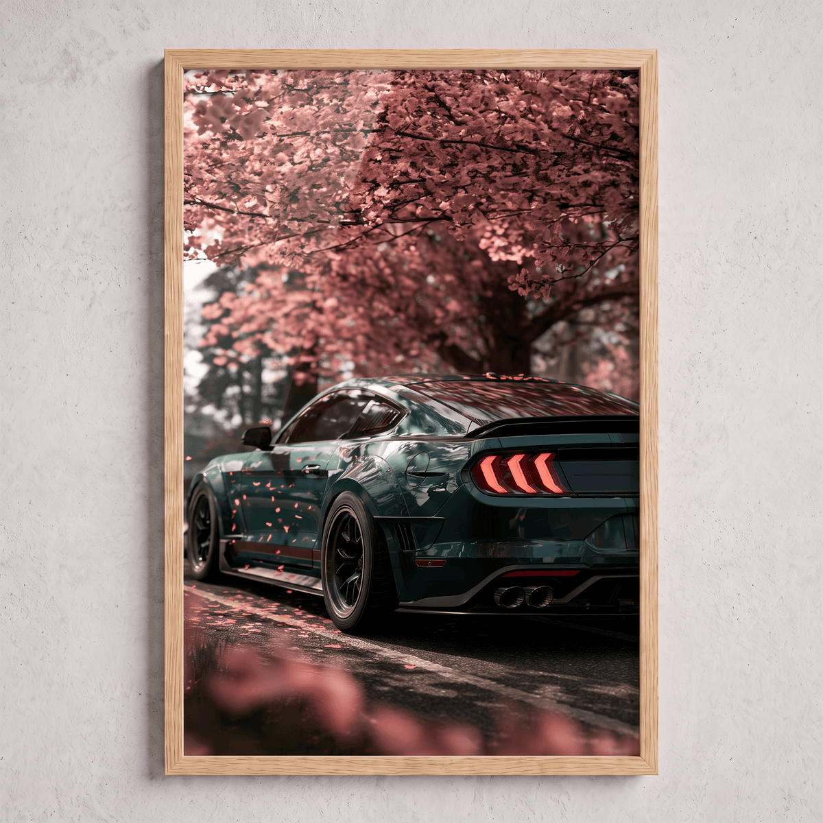 Oak framed canvas print featuring a dark green modern sports car parked beneath blooming cherry blossom trees with falling pink petals.