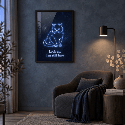 Cat memorial constellation canvas print in a black frame displayed in a moody living room setting above a modern dark armchair.