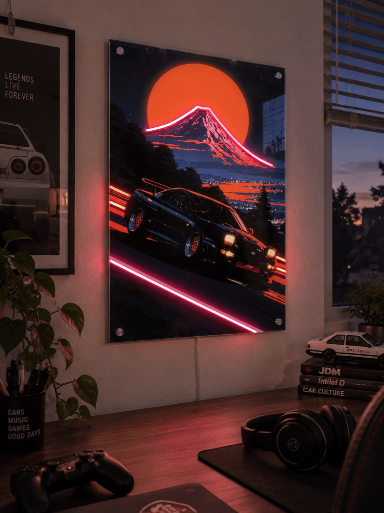 Glowing LED neon acrylic wall art of a JDM sports car drifting near Mount Fuji with synthwave neon accents in a modern gaming room desk setup.