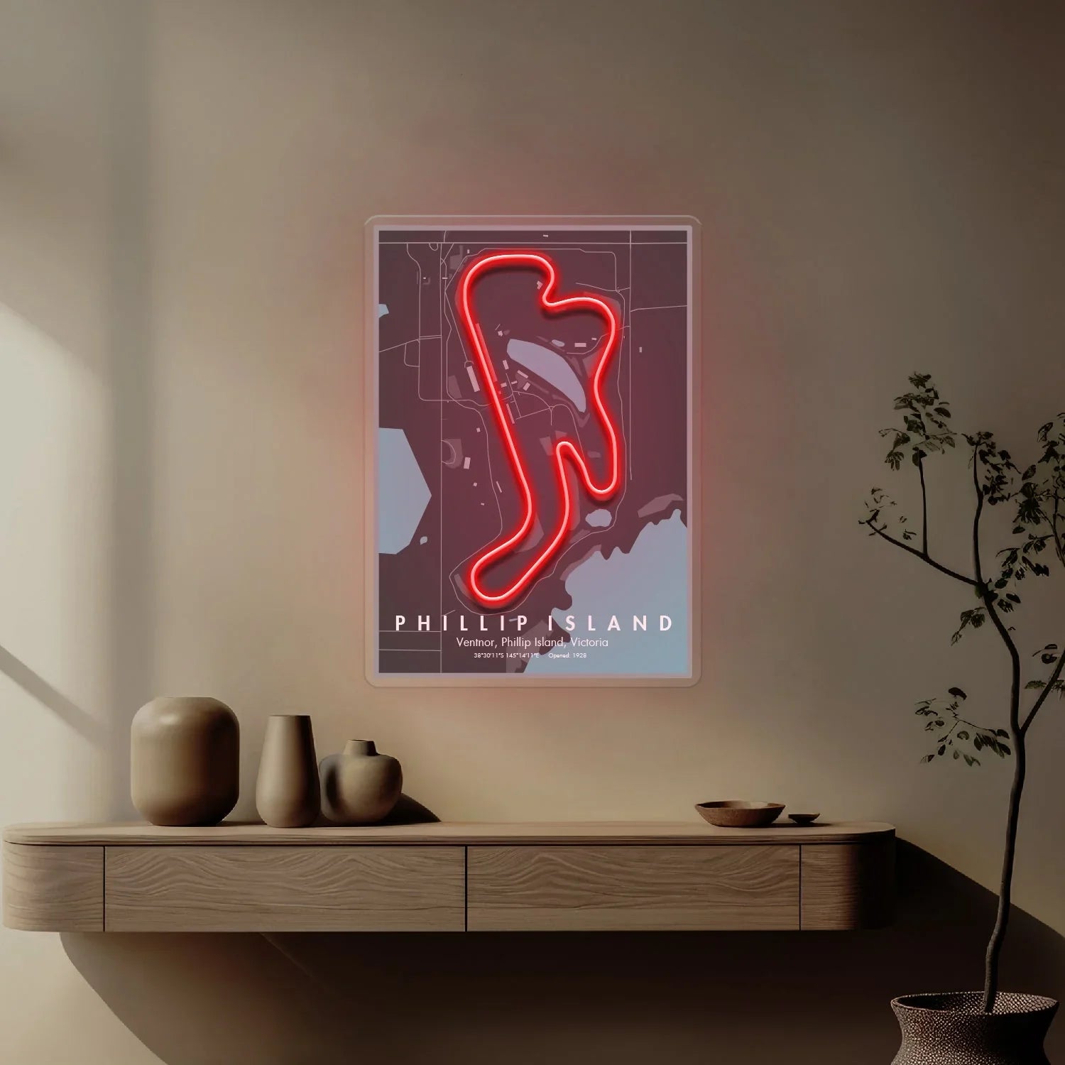 Minimalist interior with neon red Phillip Island race circuit wall art above wooden shelf and decorative vases